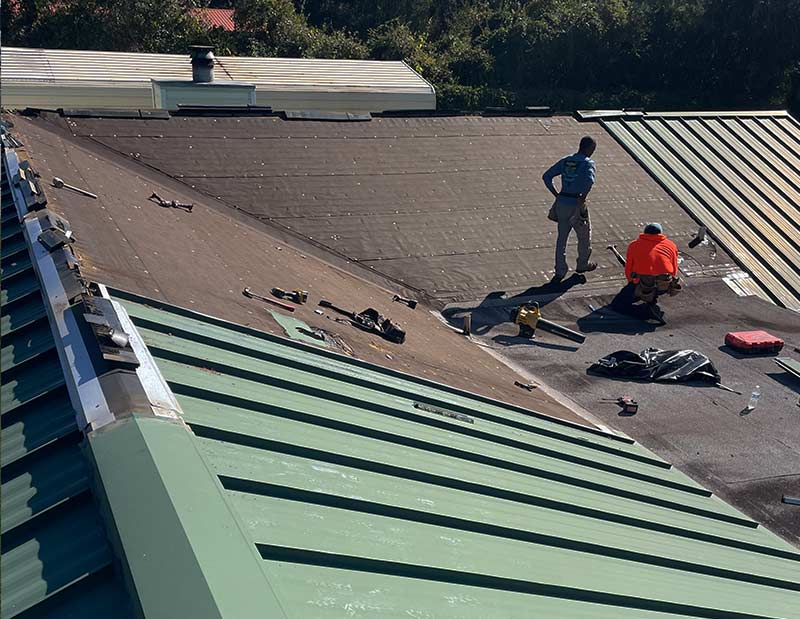 metal roof with men repairing it